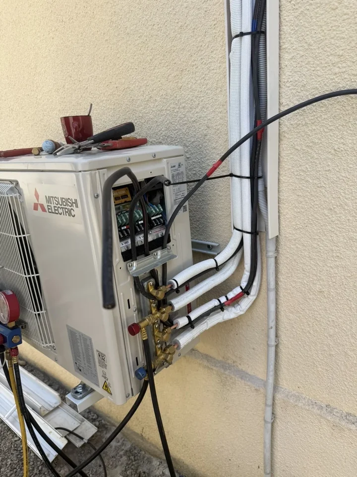 Groupe extérieur Mitsubishi avec raccordements et outils de contrôle sur un chantier CL Climatech